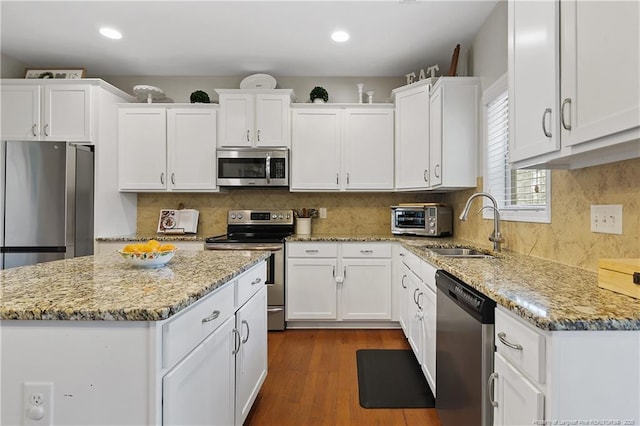 kitchen with appliances with stainless steel finishes, white cabinetry, a sink, and recessed lighting