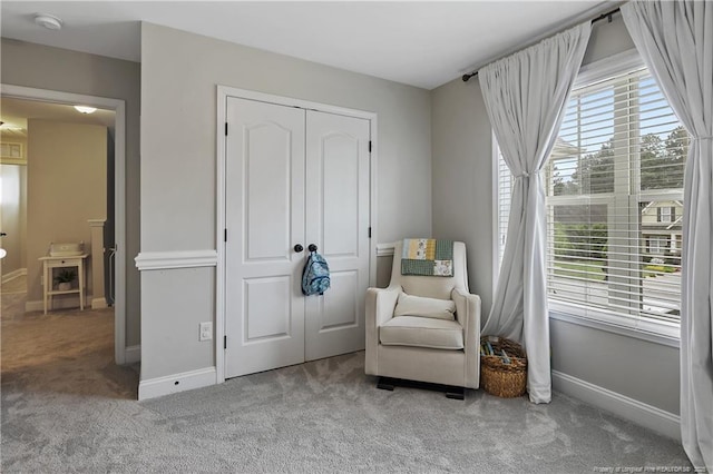 living area featuring carpet flooring and baseboards