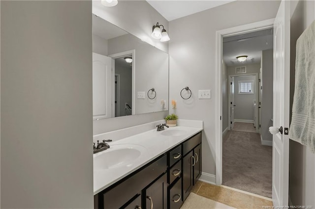 full bath with baseboards and double vanity