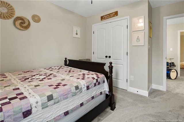 carpeted bedroom featuring baseboards and a closet