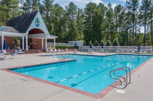 community pool featuring fence and a patio area