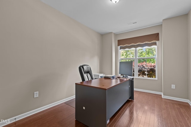 office area with baseboards, dark wood-style flooring, and visible vents
