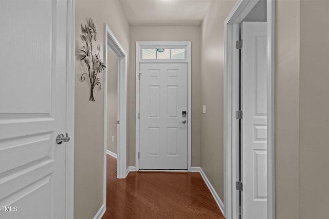 doorway to outside featuring dark wood-style flooring and baseboards
