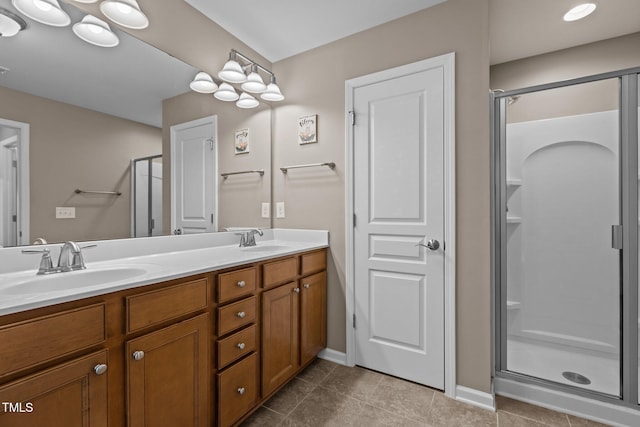 full bathroom featuring double vanity, a sink, and a stall shower