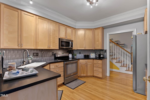 6 Chelan Ct, Durham, NC 27713 - kitchen featuring appliances with stainless steel finishes, a sink, light brown cabinetry, dark countertops, and light wood-style floors