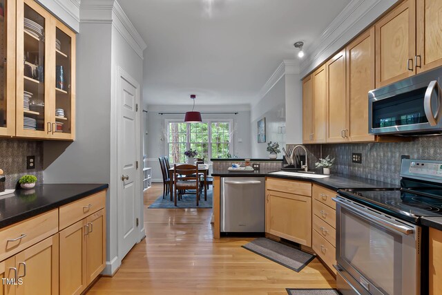 6 Chelan Ct, Durham, NC 27713 - kitchen featuring stainless steel appliances, a sink, dark countertops, light wood-style floors, and backsplash
