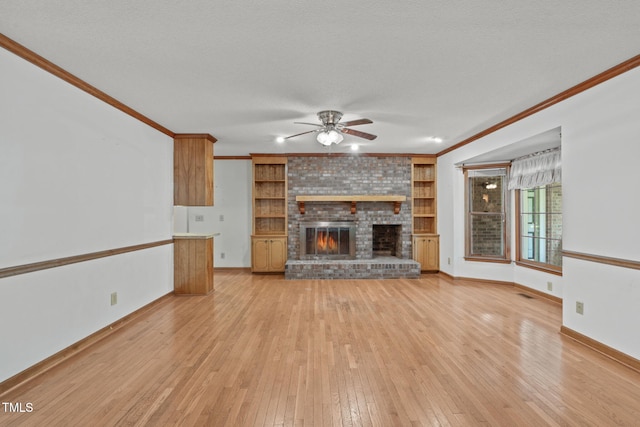 unfurnished living room featuring crown molding, a brick fireplace, a ceiling fan, baseboards, and light wood-type flooring