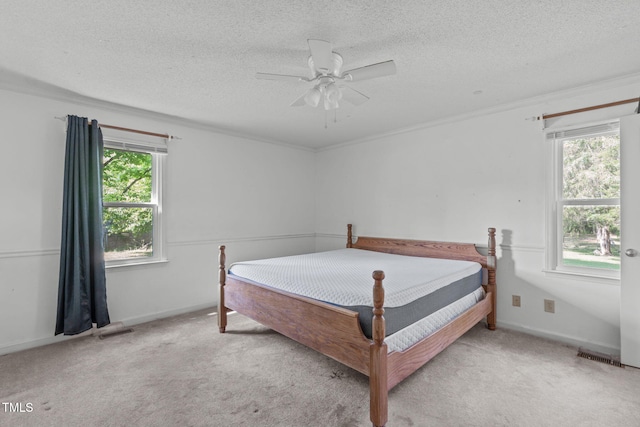 bedroom with light carpet, a textured ceiling, and visible vents