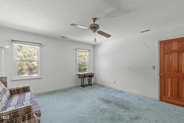unfurnished room featuring visible vents, a ceiling fan, carpet, and a textured ceiling