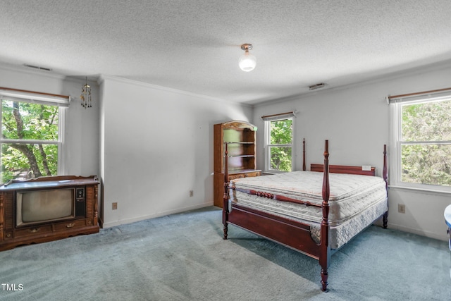 carpeted bedroom with crown molding, multiple windows, a textured ceiling, and visible vents