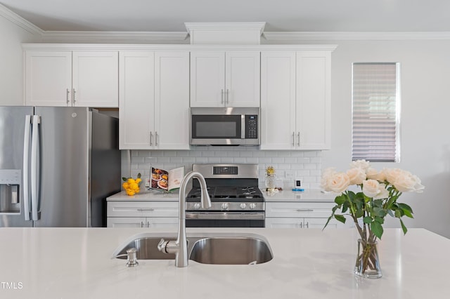321 Devon Cliffs Dr, Wake Forest, NC 27587 - kitchen featuring stainless steel appliances, a sink, light countertops, white cabinetry, and crown molding