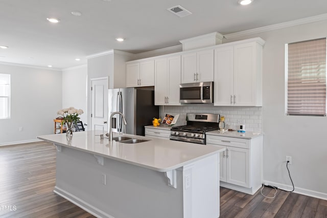 321 Devon Cliffs Dr, Wake Forest, NC 27587 - kitchen with stainless steel appliances, a sink, a center island with sink, crown molding, and baseboards