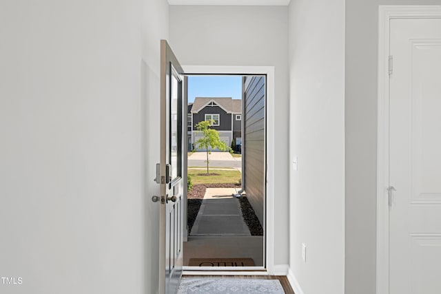 doorway with baseboards and wood finished floors