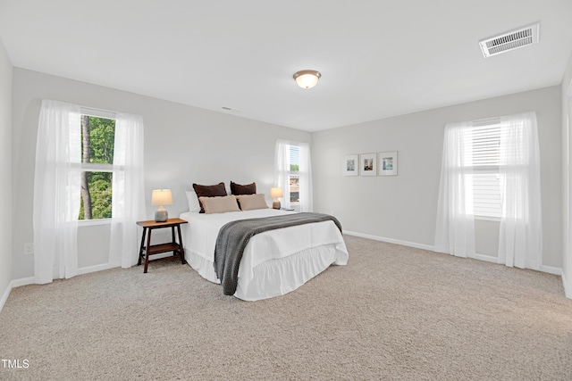bedroom with multiple windows, carpet, and visible vents