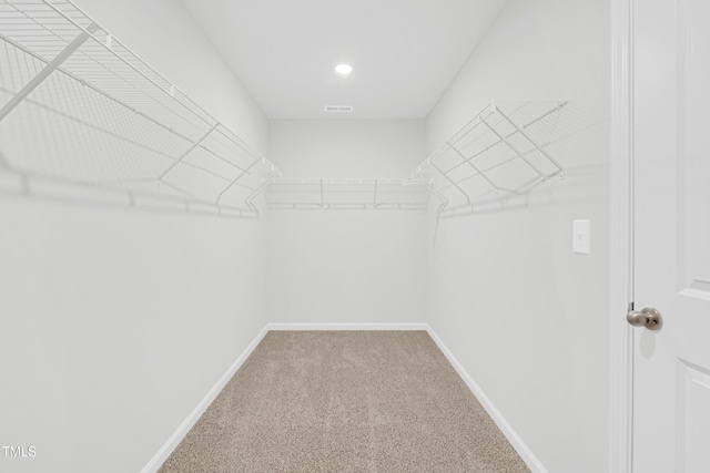 walk in closet featuring visible vents and carpet
