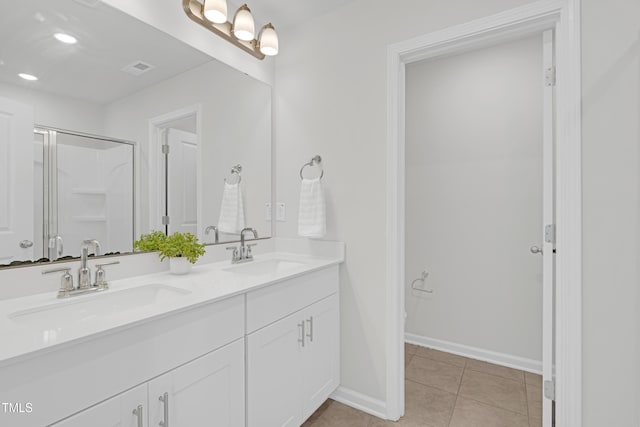 full bath with a sink, tile patterned floors, baseboards, and double vanity
