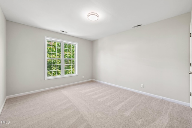 carpeted empty room featuring visible vents and baseboards