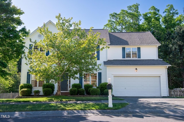 view of front of house with fence, an attached garage, concrete driveway, and a shingled roof