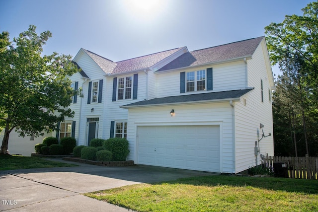 traditional home with fence, roof with shingles, an attached garage, a front lawn, and concrete driveway
