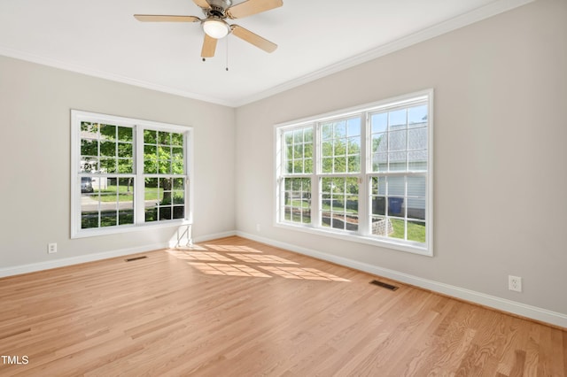 unfurnished room with visible vents, baseboards, crown molding, and wood finished floors
