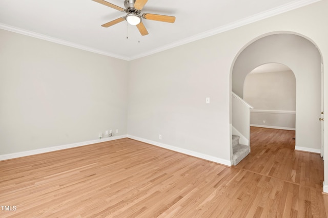 empty room with ceiling fan, stairway, baseboards, ornamental molding, and light wood-style flooring