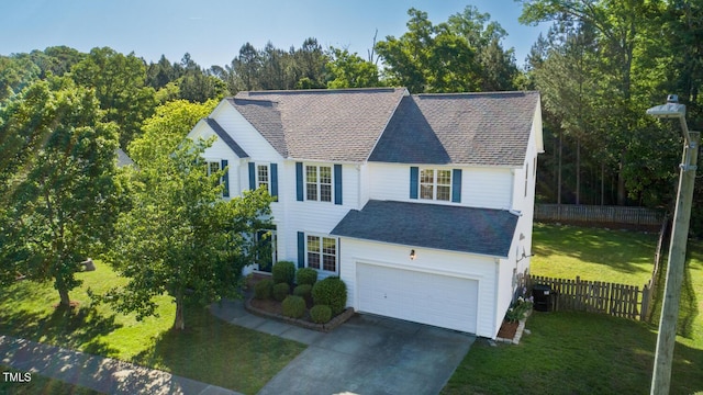 traditional home with fence, an attached garage, a front lawn, central air condition unit, and driveway