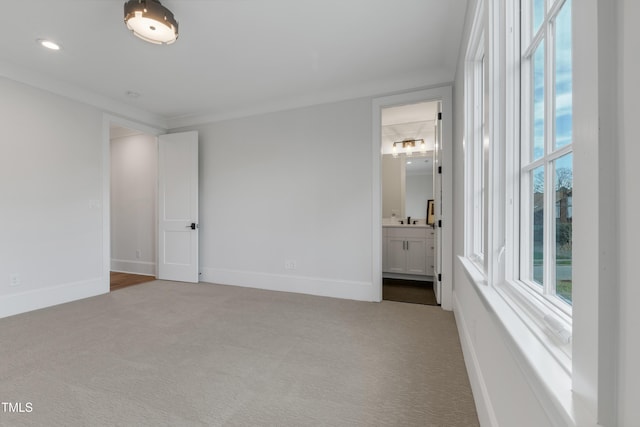 unfurnished bedroom with carpet, baseboards, and multiple windows