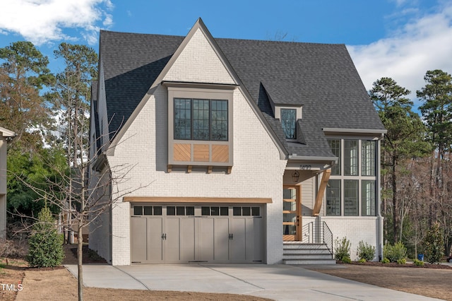 view of front of property with driveway, roof with shingles, board and batten siding, and a garage