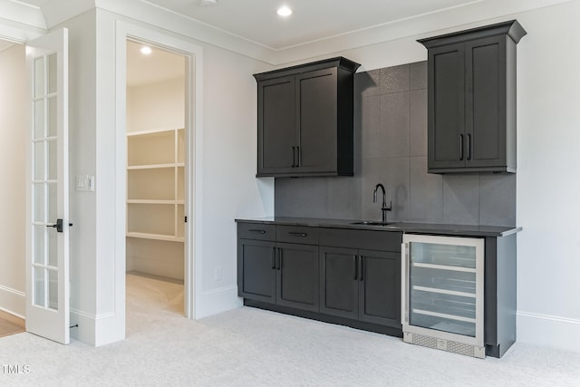 bar with baseboards, carpet floors, a sink, wet bar, and wine cooler