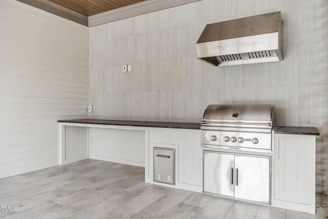 kitchen featuring tile walls, dark countertops, light wood-style flooring, and wall chimney exhaust hood