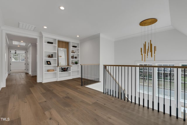hall with recessed lighting, an upstairs landing, visible vents, ornamental molding, and wood finished floors