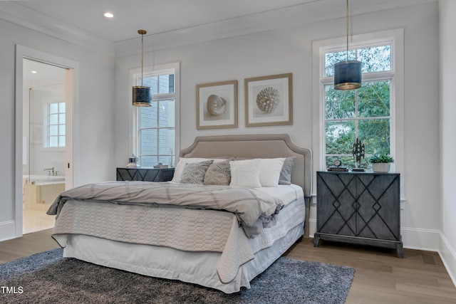 bedroom featuring connected bathroom, crown molding, baseboards, recessed lighting, and wood finished floors
