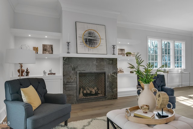 living room featuring crown molding, recessed lighting, wood finished floors, and a fireplace