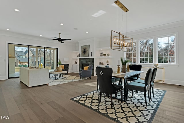 dining area with a fireplace, crown molding, and recessed lighting