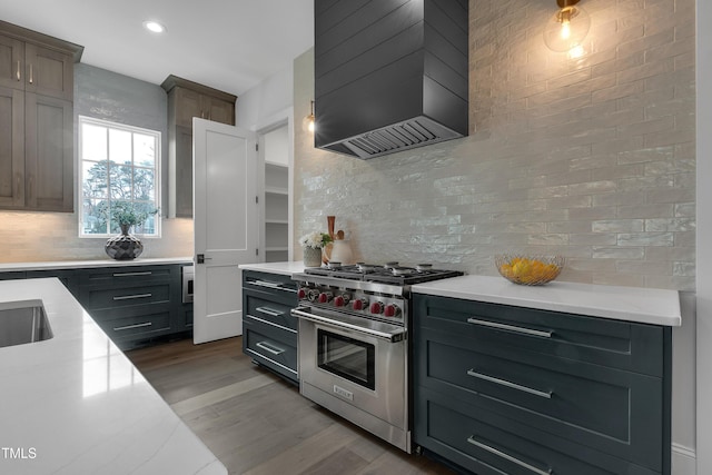 kitchen with tasteful backsplash, designer range, premium range hood, recessed lighting, and dark wood-type flooring