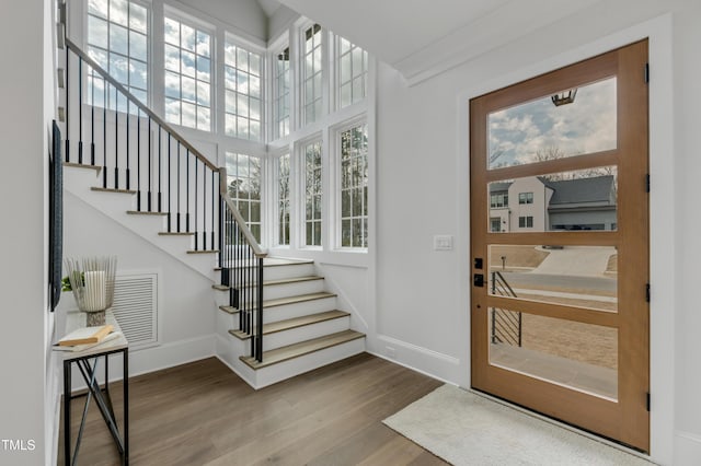 foyer entrance featuring stairs, visible vents, wood finished floors, and baseboards