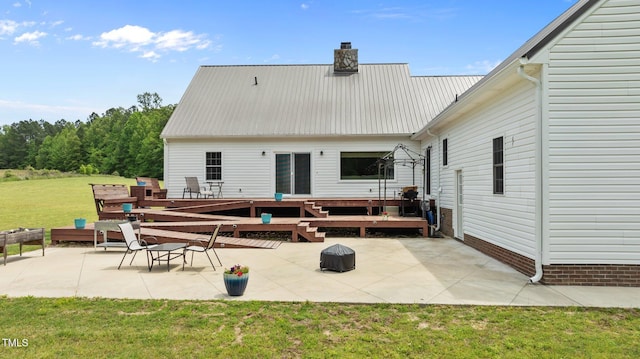 675 Anderson Creek Rd, Henderson, NC 27537 - rear view of property featuring a lawn, a patio, a chimney, and metal roof
