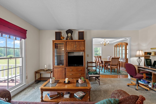 675 Anderson Creek Rd, Henderson, NC 27537 - living room featuring carpet floors, a textured ceiling, and a notable chandelier