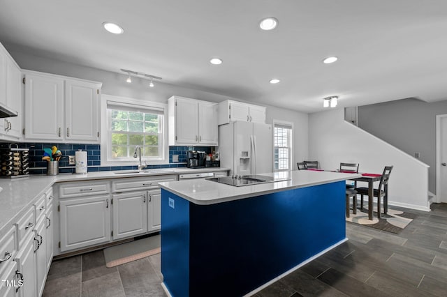 675 Anderson Creek Rd, Henderson, NC 27537 - kitchen featuring black electric stovetop, white refrigerator with ice dispenser, a center island, tasteful backsplash, and a sink