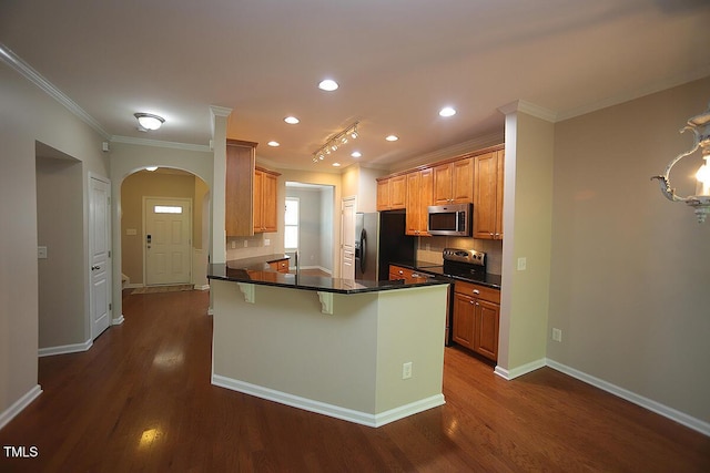 kitchen featuring stainless steel appliances, decorative backsplash, a peninsula, ornamental molding, and arched walkways