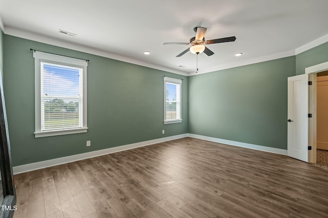 spare room with baseboards, visible vents, wood finished floors, and ceiling fan