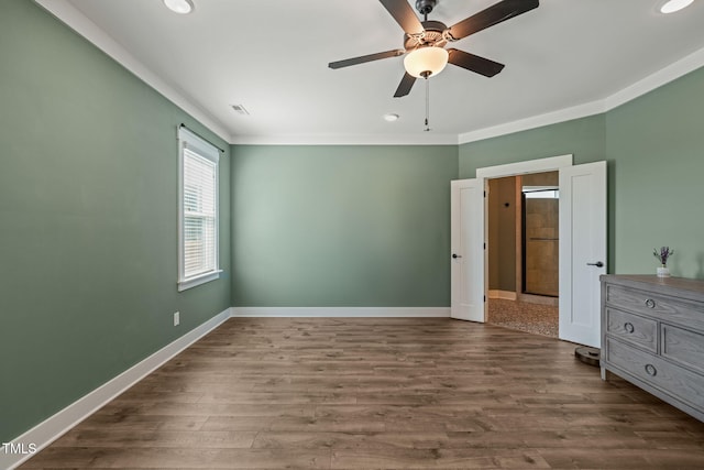 unfurnished bedroom featuring baseboards, recessed lighting, crown molding, and dark wood finished floors