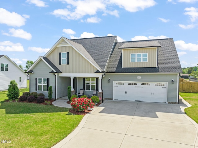 craftsman inspired home featuring a front yard, driveway, covered porch, and board and batten siding