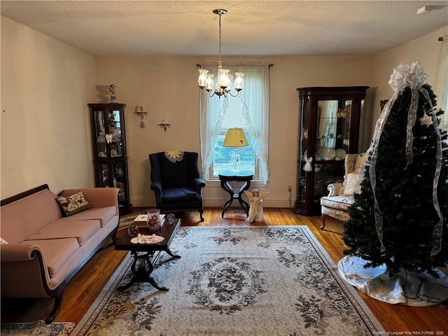 3903 Daytona Rd, Fayetteville, NC 28311 - living room featuring a chandelier, wood finished floors, a textured ceiling, and baseboards