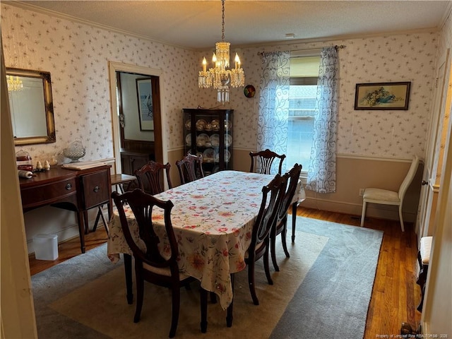 3903 Daytona Rd, Fayetteville, NC 28311 - dining area featuring crown molding, a chandelier, wallpapered walls, a wainscoted wall, and wood finished floors