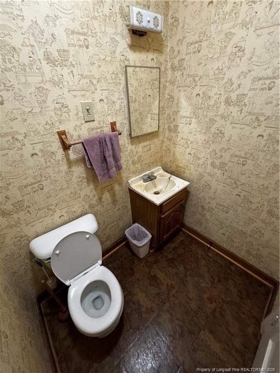 3903 Daytona Rd, Fayetteville, NC 28311 - bathroom with toilet, wallpapered walls, a sink, and baseboards