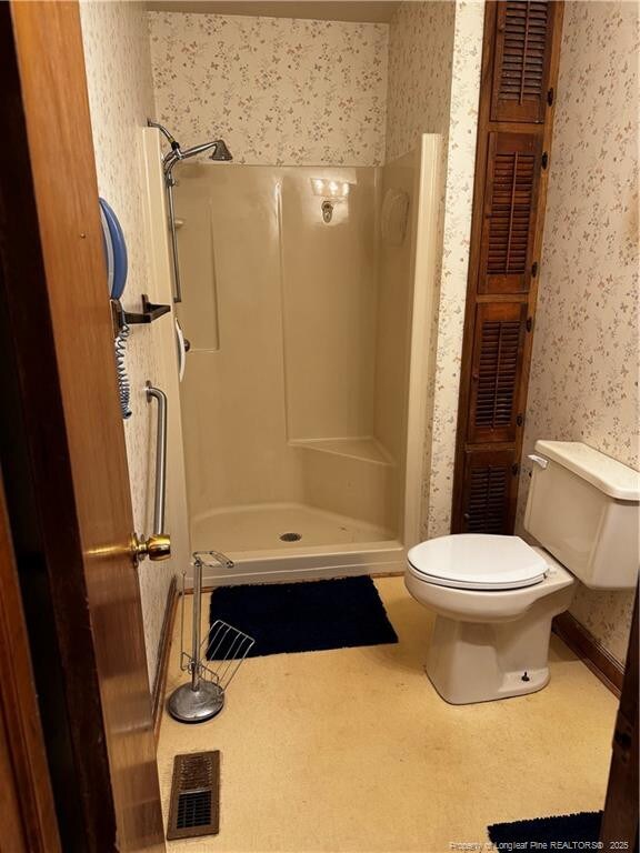 3903 Daytona Rd, Fayetteville, NC 28311 - bathroom with wallpapered walls, a stall shower, and toilet