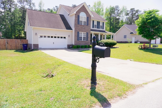 145 Ironwood Way, Raeford, NC 28376 - colonial house with brick siding, fence, a garage, a front yard, and concrete driveway