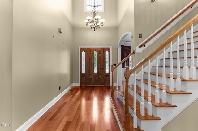 7212 Donneeford Rd, Wake Forest, NC 27587 - foyer with a towering ceiling, wood finished floors, stairway, baseboards, and a chandelier