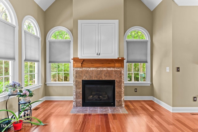 7212 Donneeford Rd, Wake Forest, NC 27587 - living room featuring wood finished floors, high vaulted ceiling, a tiled fireplace, and baseboards